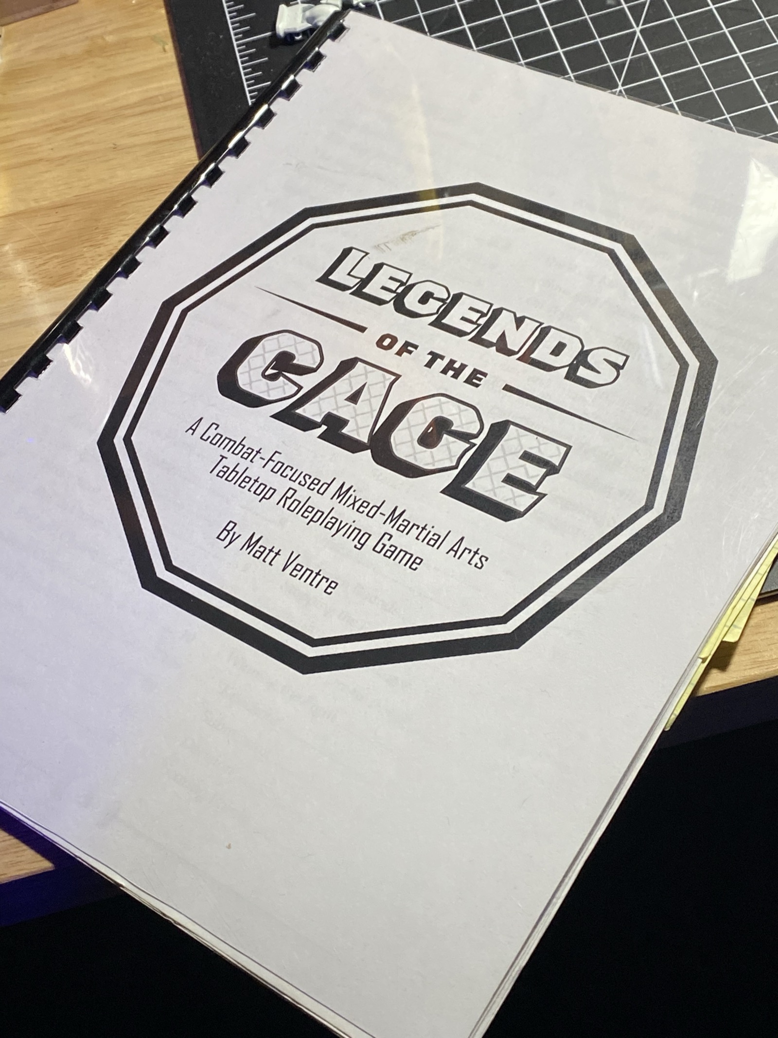 Physical spiral-bound prototype of Legacy of the Cage: A Combat-Focused Mixed-Martial Arts Tabletop Roleplaying Game